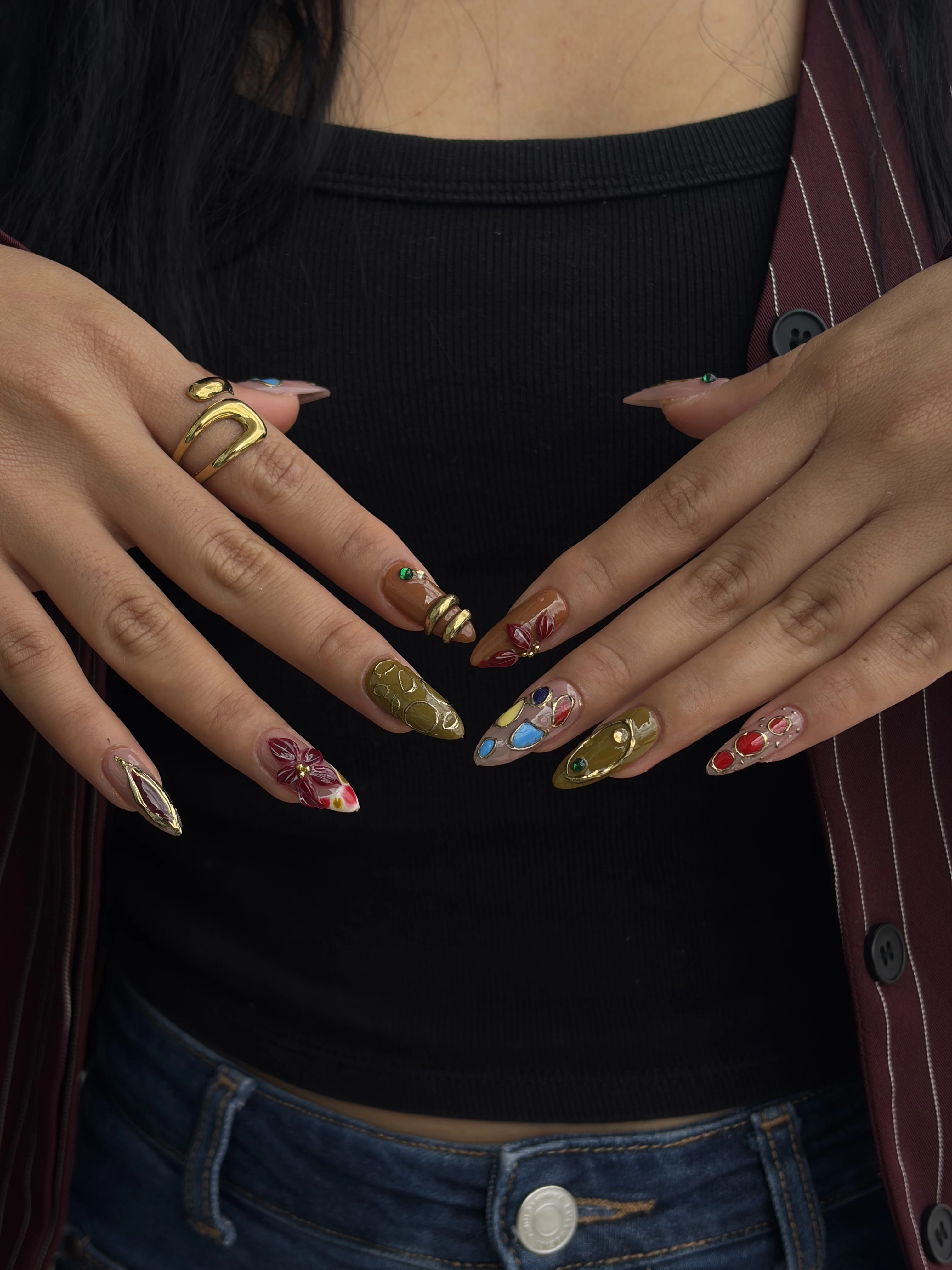 Manos con uñas almendradas con dorado, cromo y diseños a mano