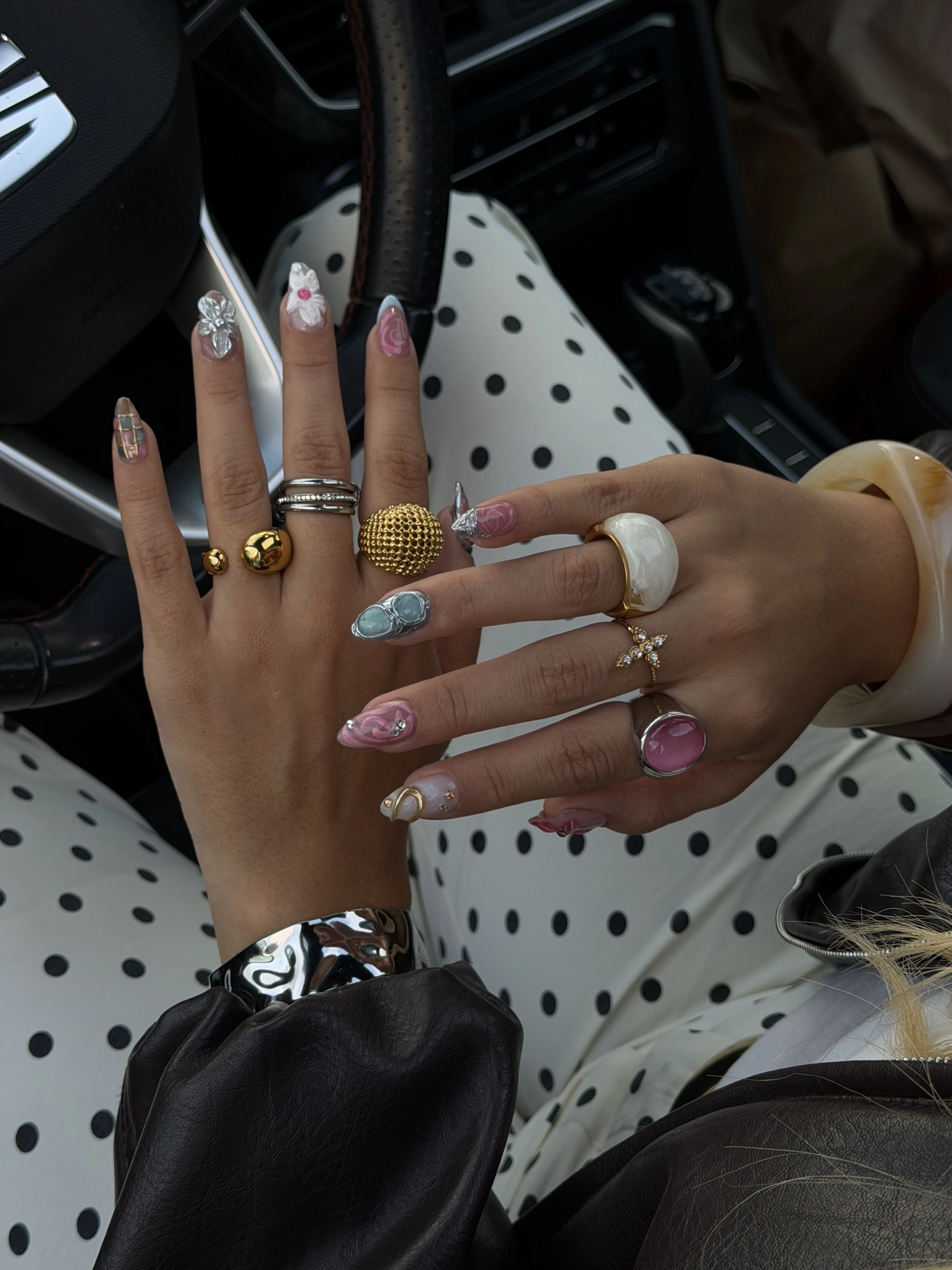 Uñas con flores en relieve y anillos dorados